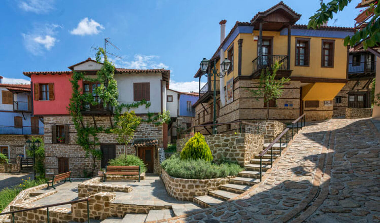 Traditional stone and colored houses on a paved road.