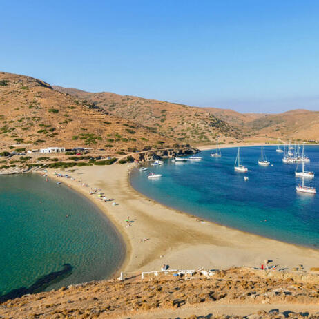 Λεπτή λωρίδα γης που σχηματίζει 2 παραλίες. Πολλά ιστιοπλοϊκά σκάφη στη μια. 'Ηπιοι λόφοι με λίγα κτίσματα.