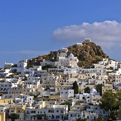 Άσπρα σπίτια πυκνοχτισμένα στην πλαγιά μικρού λόφου. Στην κορυφή 3 μικρές εκκλησίες.