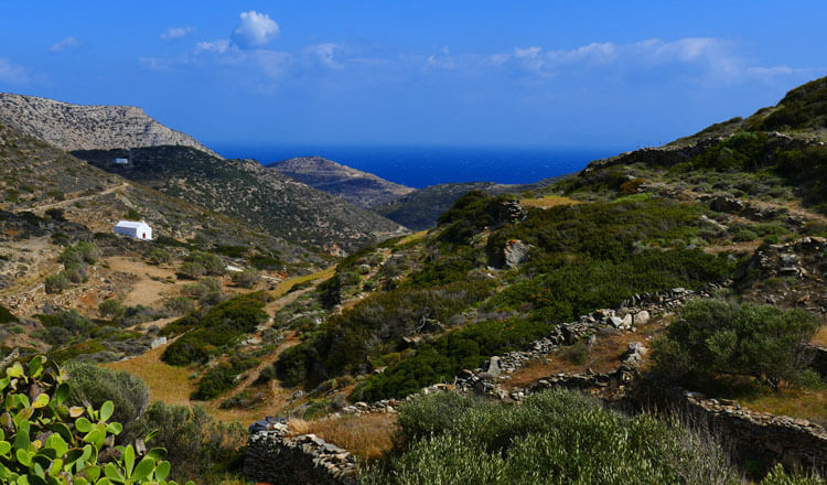 Small white church between quiet hills and in the background the sea.