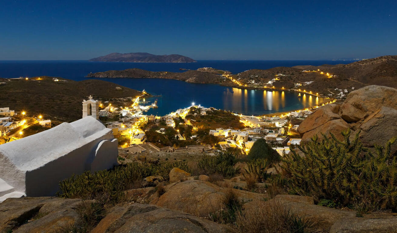 Night view over beach with settlement and a church in the foreground.