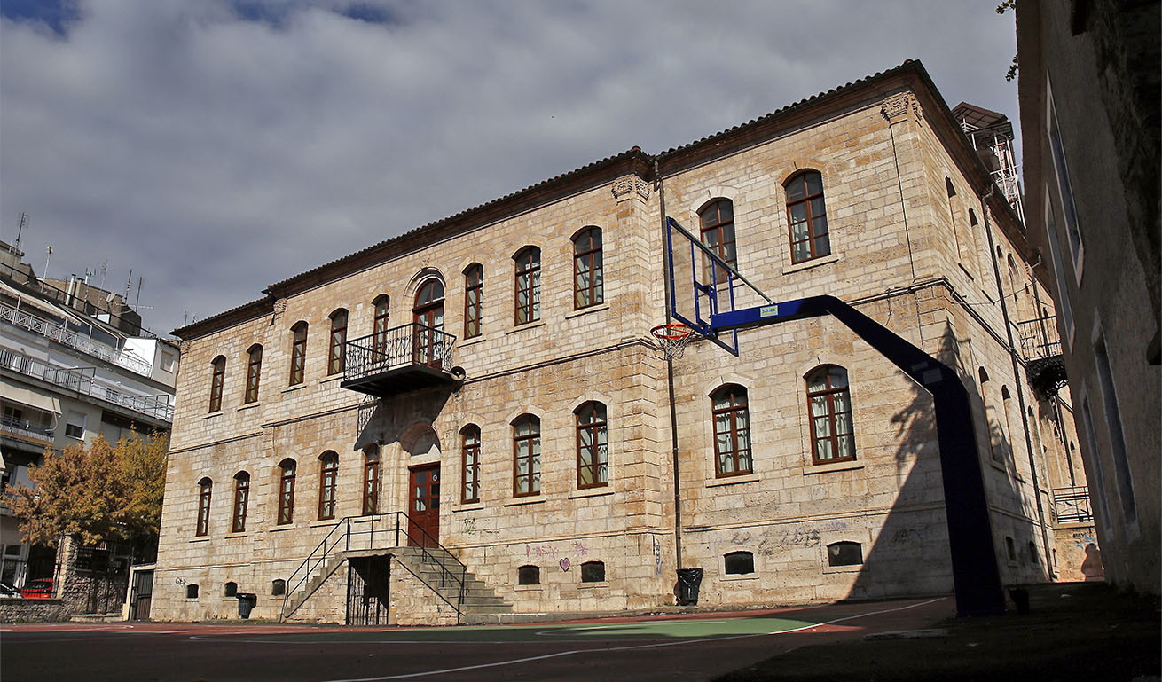 Μεγάλο διώροφο πέτρινο παραδοσιακό κτίσμα με μπασκέτα στην αυλή του.