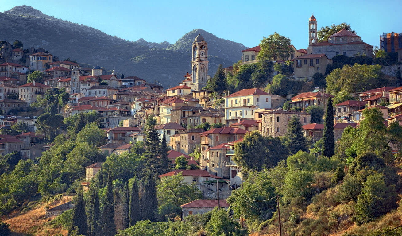 Panoramic view of Dimitsana village with the traditinal houses and the church at the top, as well as trees