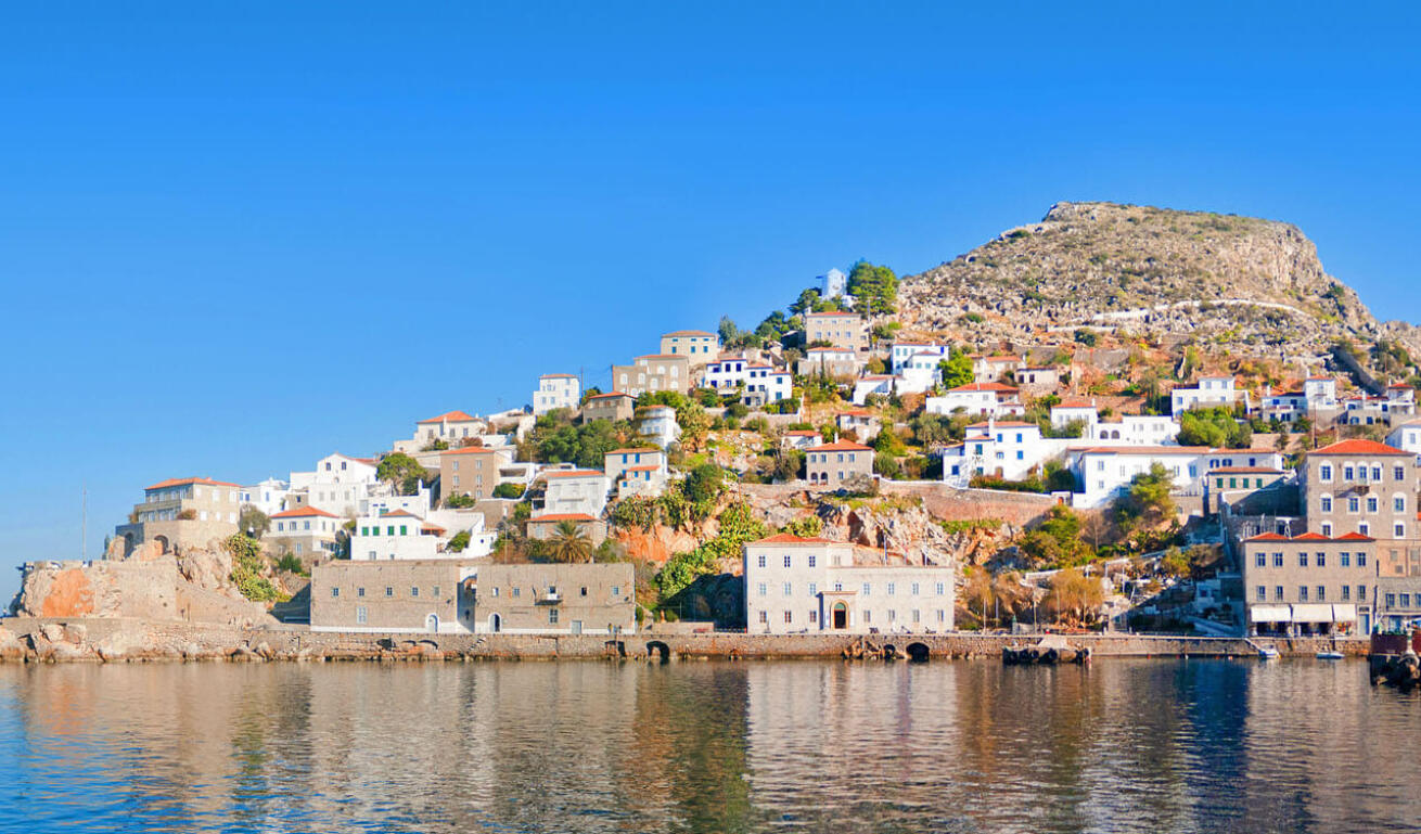 Cape with stone houses built amphitheatrically above the calm sea. 