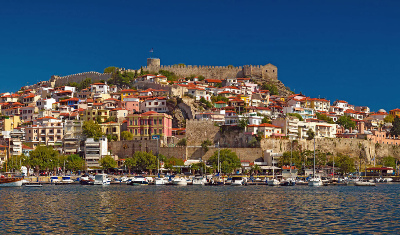 Panoramic view of the port of the city with many traditional houses and the castle at the top