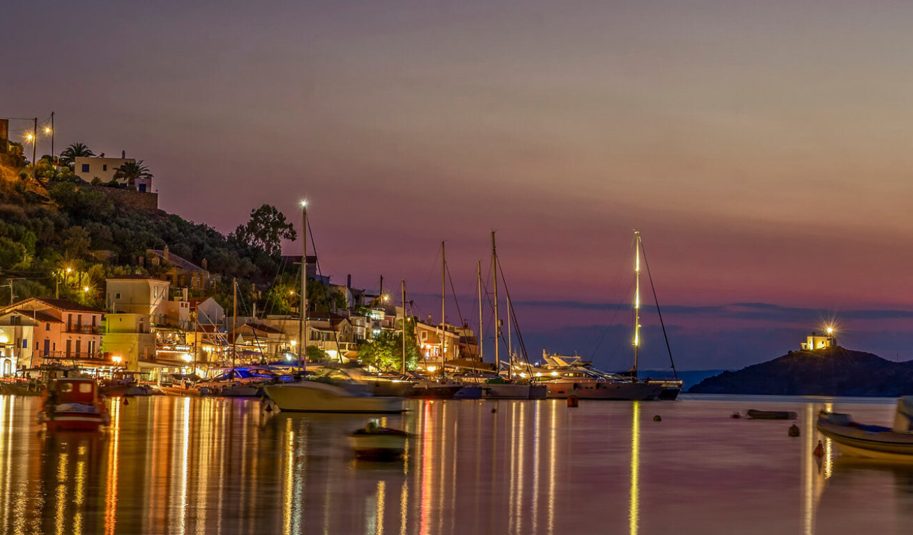 Small picturesque harbor with small boats at night with lights. 
