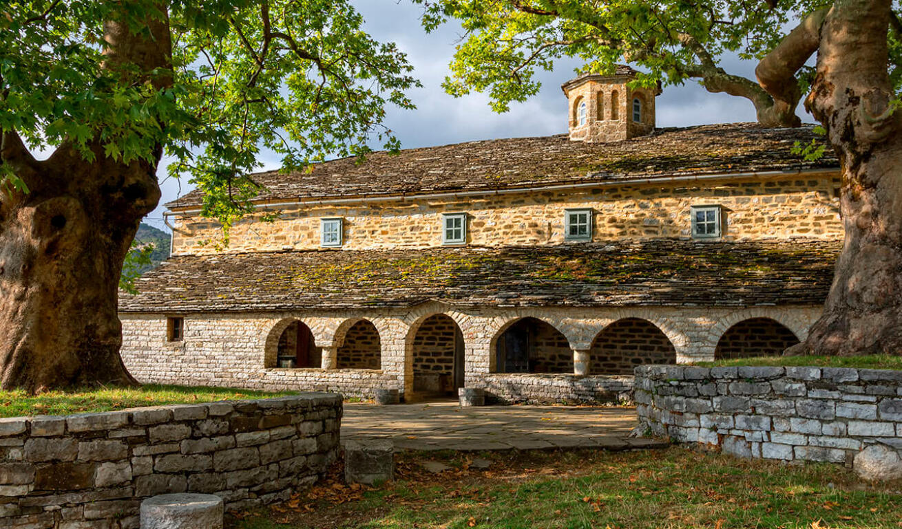 Άποψη του χωριού με δύο πλάτανους και στο βάθος μία πετρόκτιστη εκκλησία