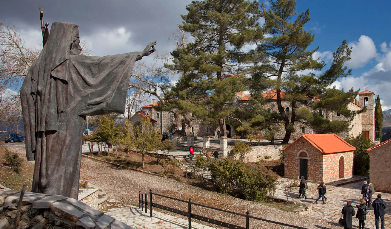 Agia Lavra Monastery on the background, with trees surοunding it