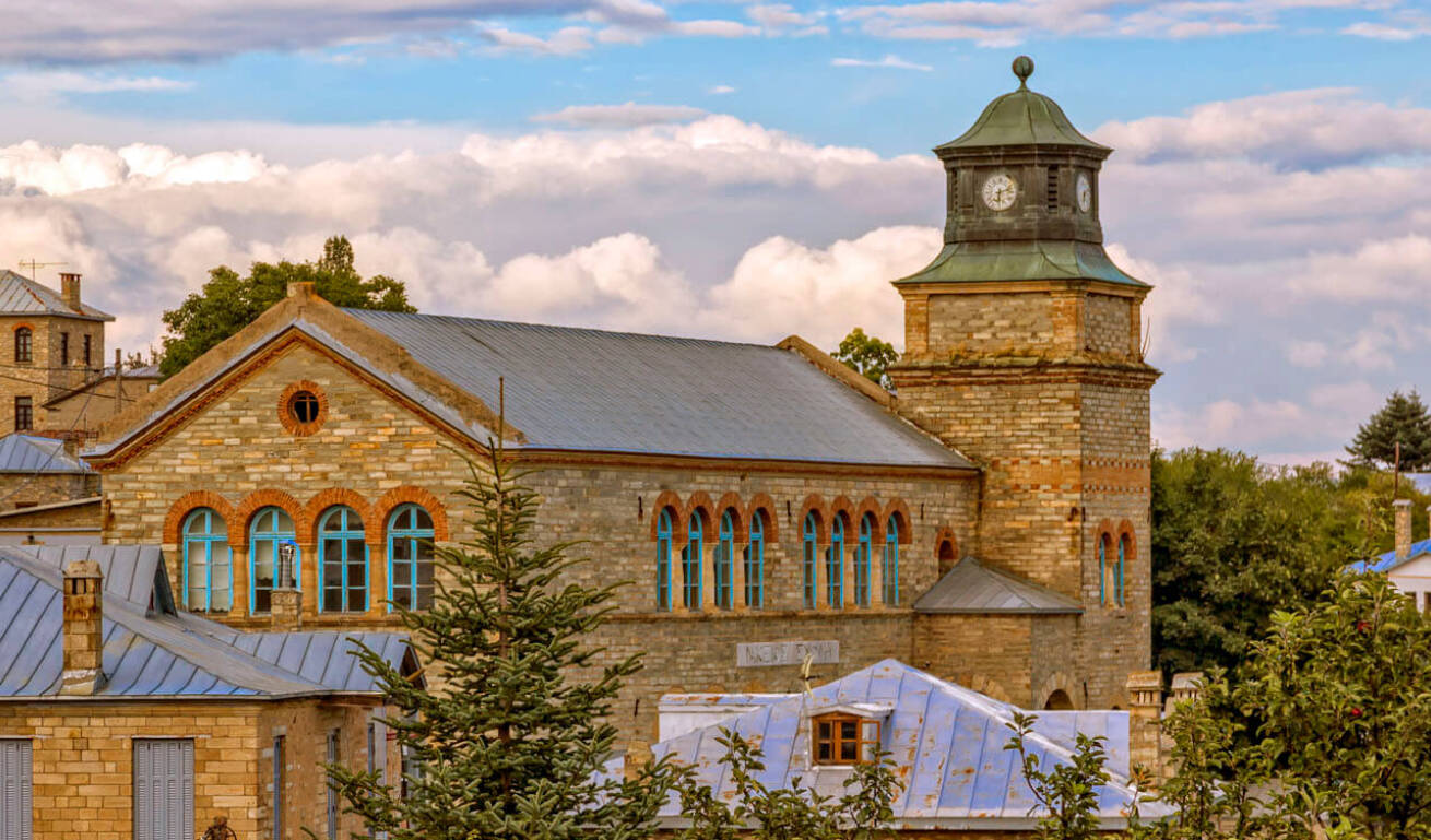 Traditional stone-built building surrounded by many trees