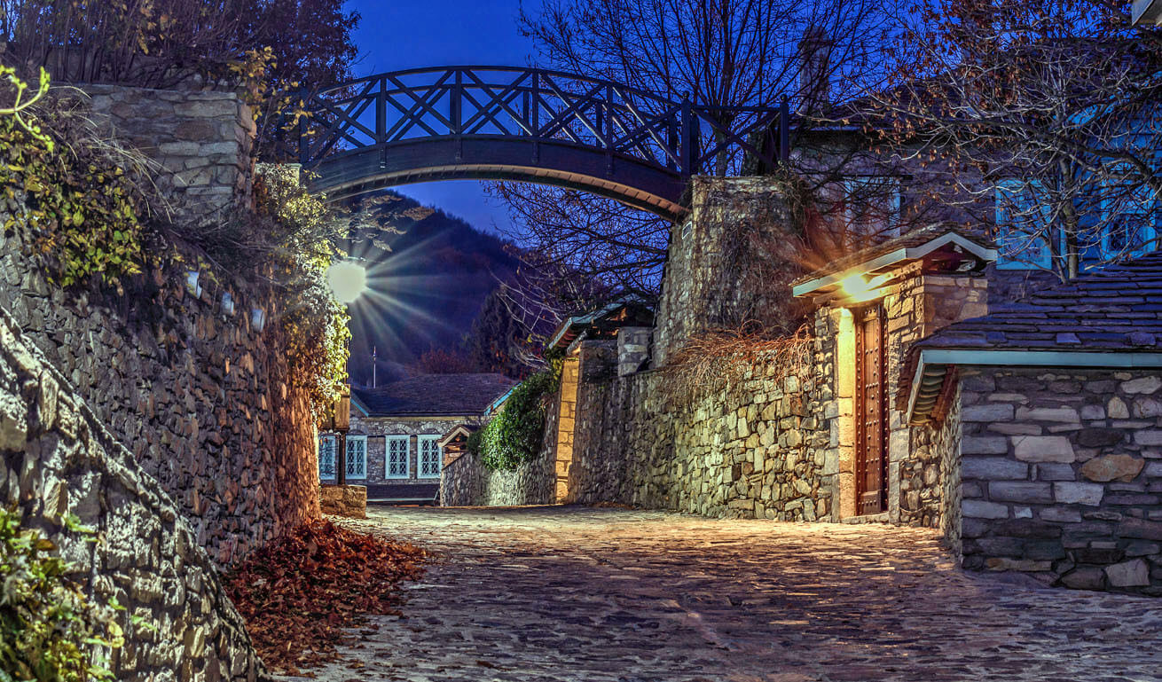Illuminated stone-built road of the village at night
