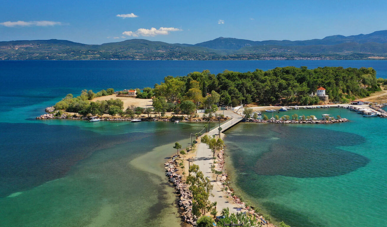 Pezonisi islet in Eretria, that you can go on foot, full with green trees and surrounded by greenish blue sea waters