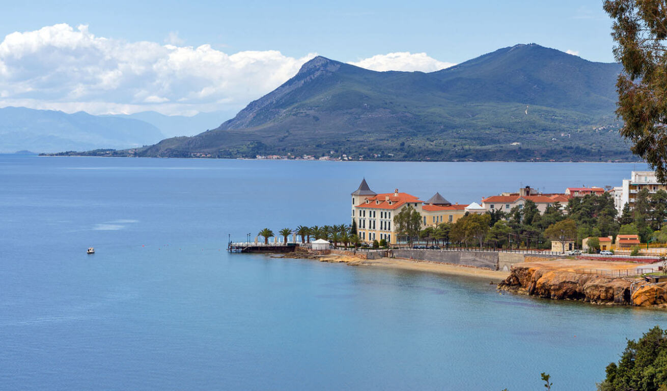 View of the town of Aidipsos with the traditional houses surrounded by green trees overlooking the sea