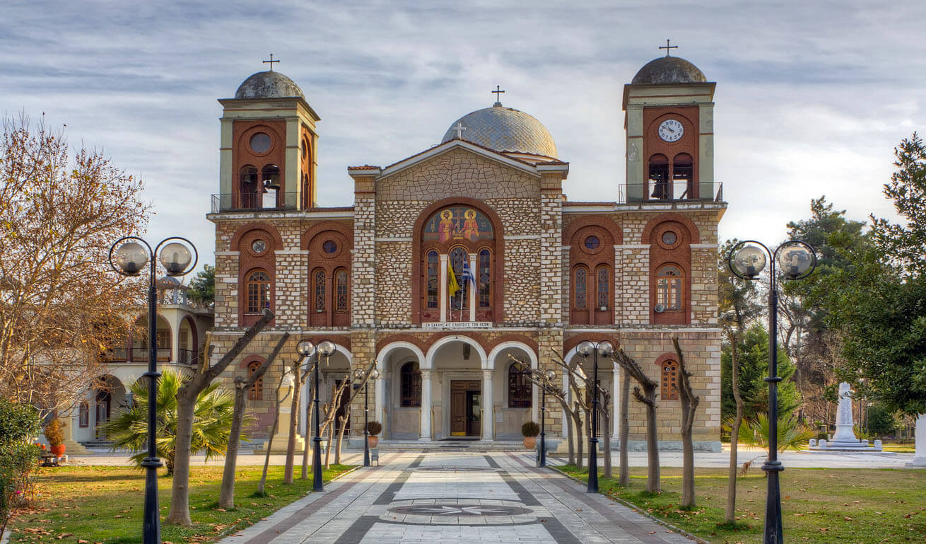 Impressive stone-built church of the town, between trees
