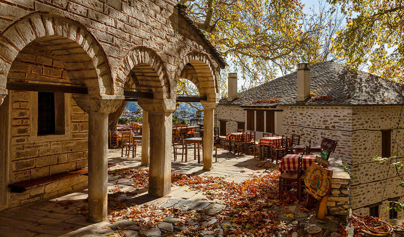 Άποψη της πλατείας του χωριού με τραπέζια, κάτω από τον πλάτανο