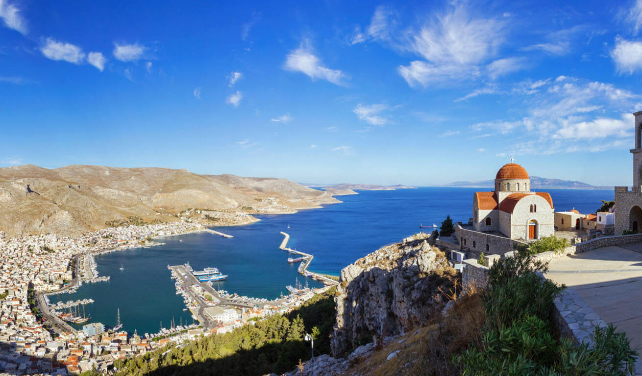 Πανοραμική άποψη του νησιού ατενίζοντας τα παραδοσιακά σπίτια και το λιμάνι και στην κορυφή να δεσπόζει η εκκλησία με το καμπαναριό