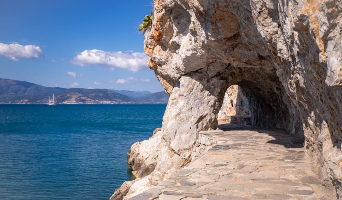 stone pathway going under archway with views of sea