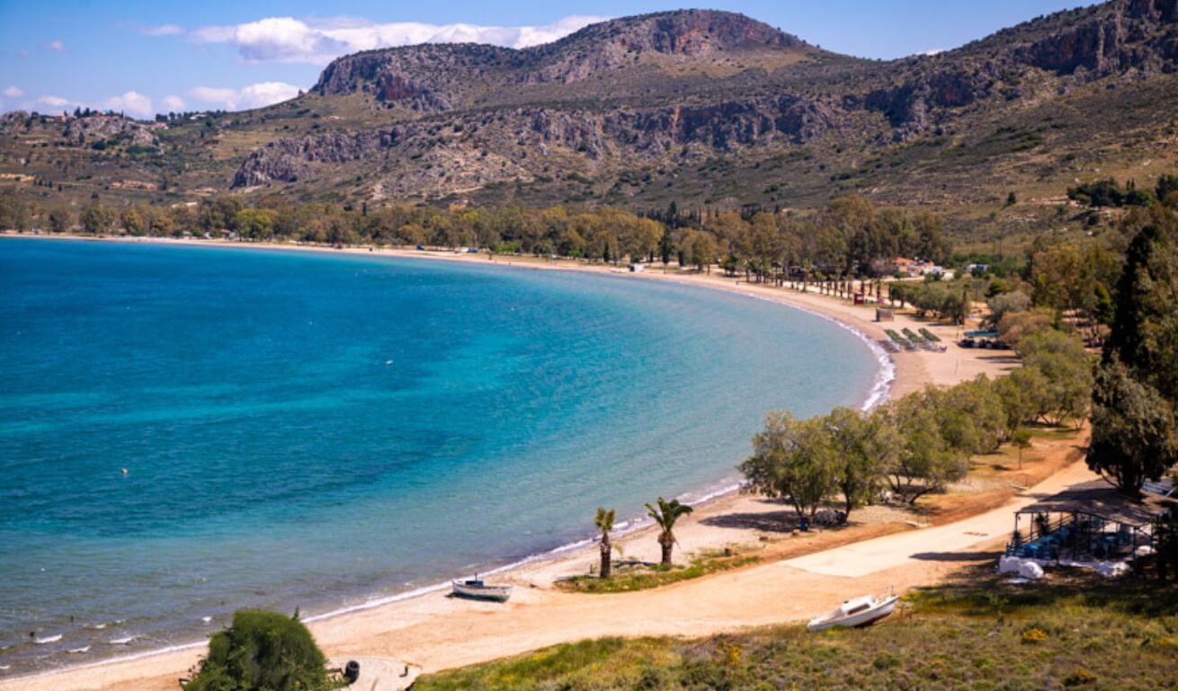 aerial view of curving Karathoas Beach with mountains in the background