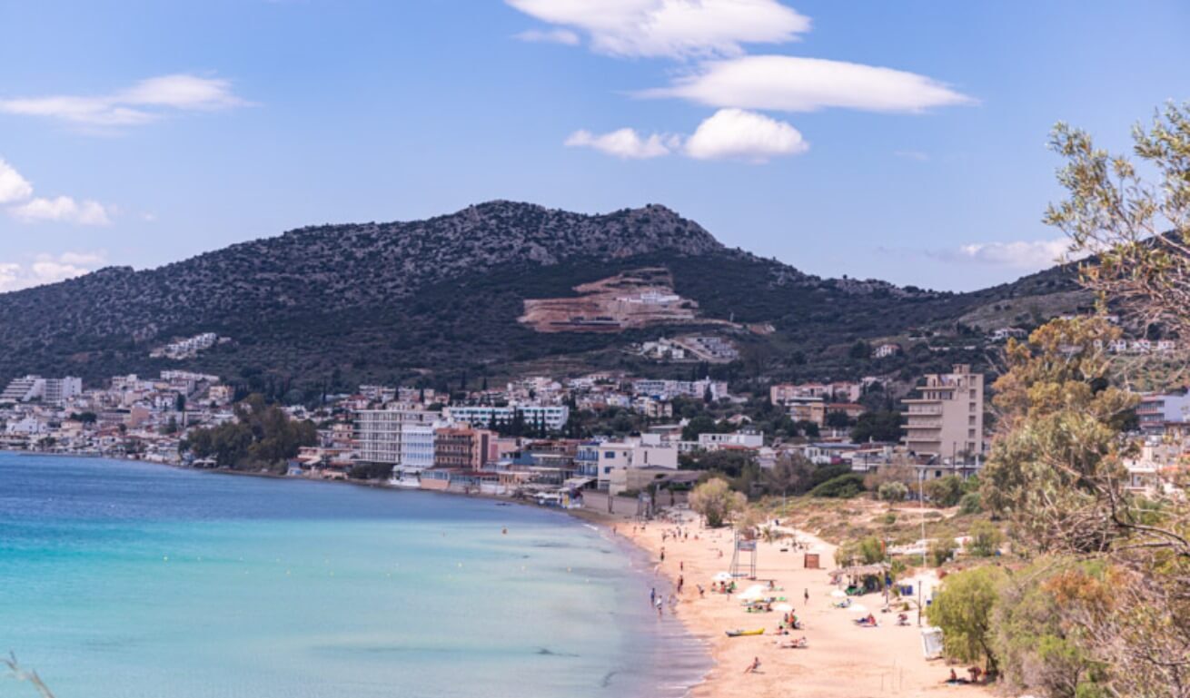 people on Tolo Beach and mountain in the background