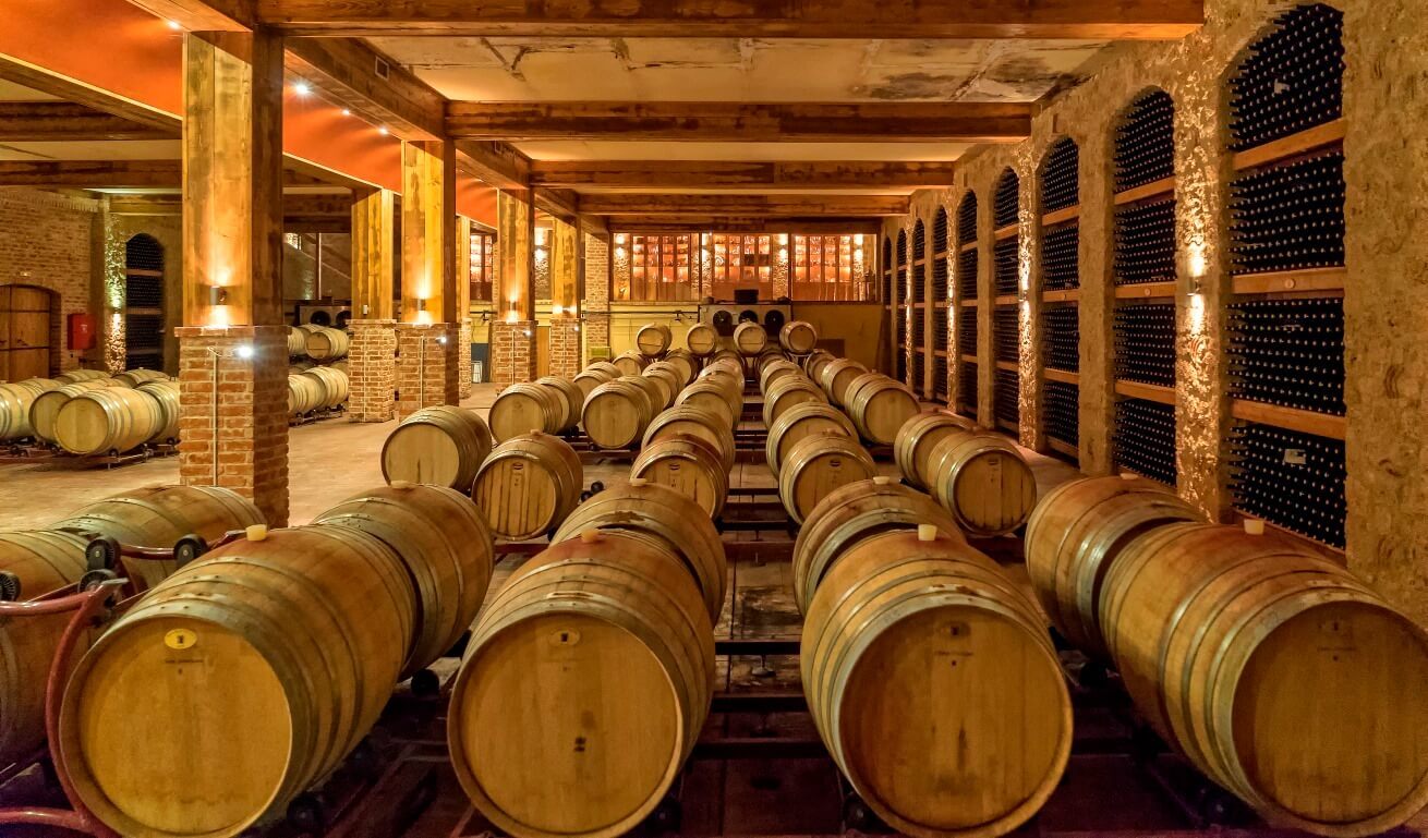 many rows of wooden wine-filled casks lining the caves and cellars of the winery.