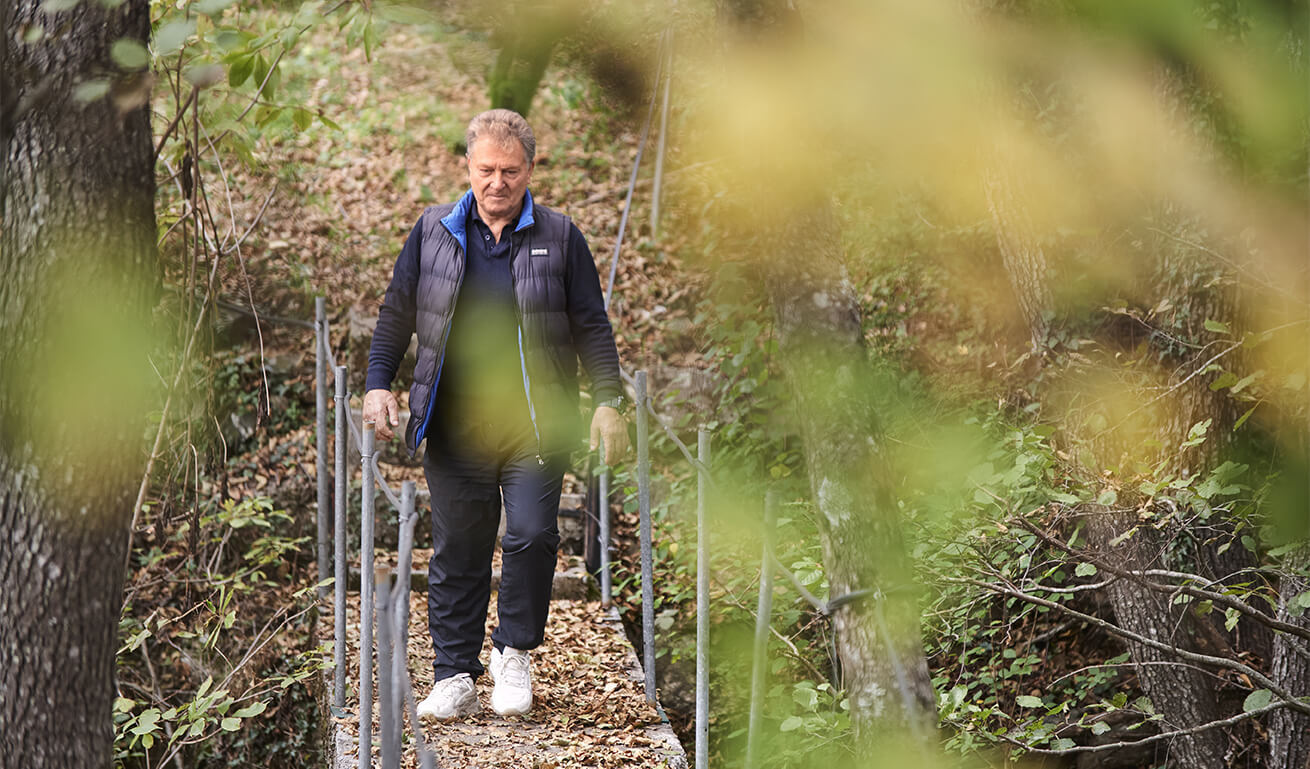 Person walking on a forest trail using crutches.