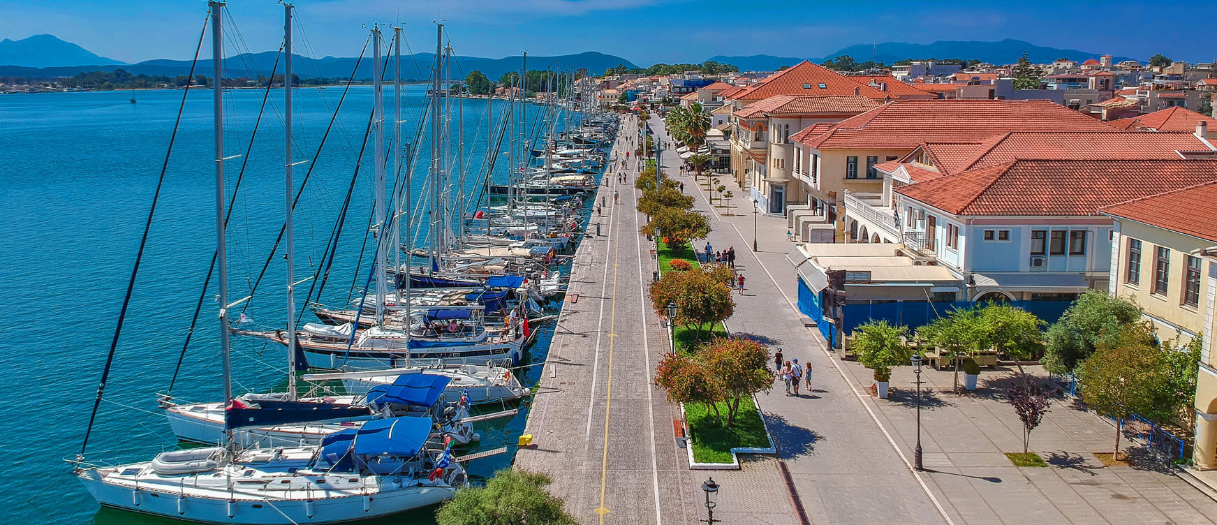 View of the port from above, with a lot of sailing boats anchored and many traditional houses