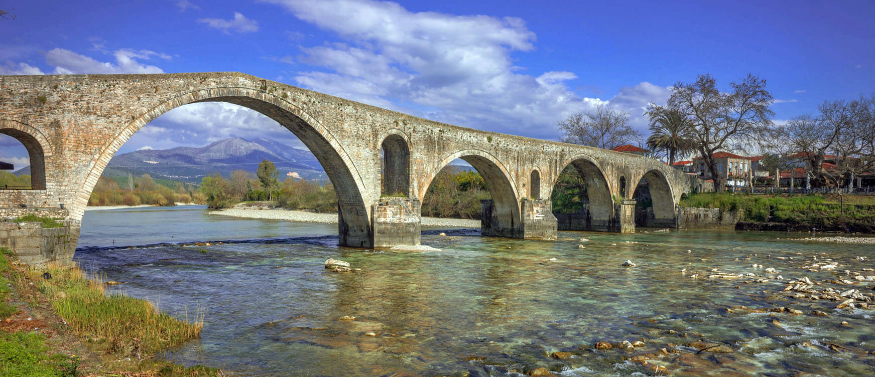 View of the impressive bridge of the town, with the river and between the two banks you can see the traditional houses with tile roofs