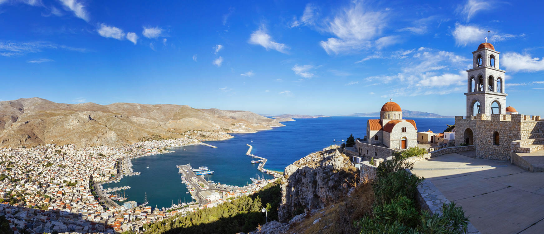 Panoramic view of the island overlooking the traditional houses and the port and at the top dominates the church with the belltower