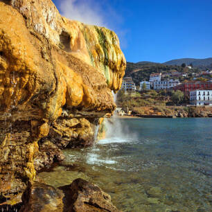 View of the thermal baths of Aidipsos with steep rocks and the blue sea