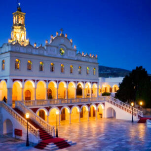 Large illuminated church with many arches and a bell tower. 