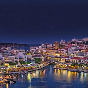 Πανοραμική άποψη της πόλης του Αγίου Νικολάου, με τα παραδοσιακά σπίτια και το φωταγωγημένο λιμάνι τη νύχτα