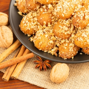 Greek biscuits known as melomakarona, dunked in honey syrup and sprinkled with crushed walnuts sprinkled and cinnamon spice