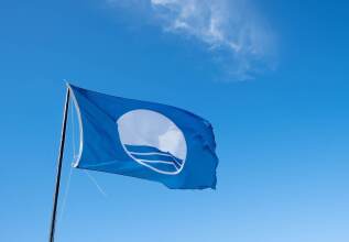 an image showing a blue sky and a blue flag for clean beaches