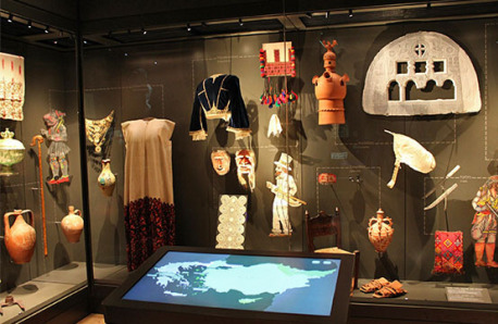 Large glass museum display case with utilitarian and decorative objects from Hellenism.