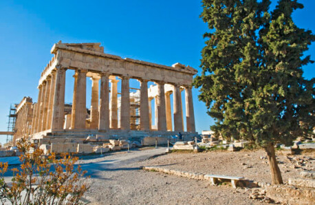 Αρχαιολογικός χώρος με μεγάλο ναό και ένα μεγάλο κυπαρίσσι.