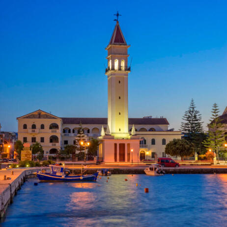 View of the port of the island during dusk with the church of Agios Dionysios dominating the area
