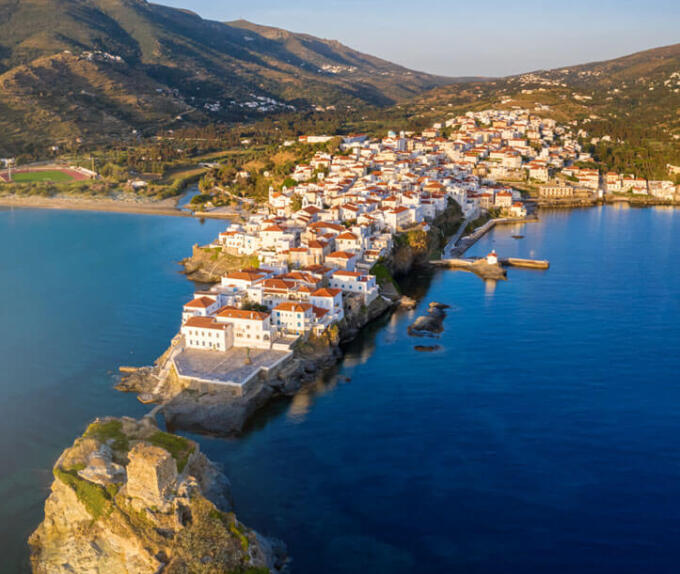 Αεροφωτογραφία χερσονήσου με παραδοσιακό οικισμό και στο βάθος μια παραλία και λόφοι.