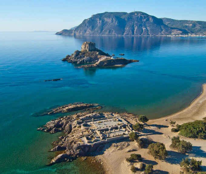 View of the beach of the island from above with greenish blue waters and islets