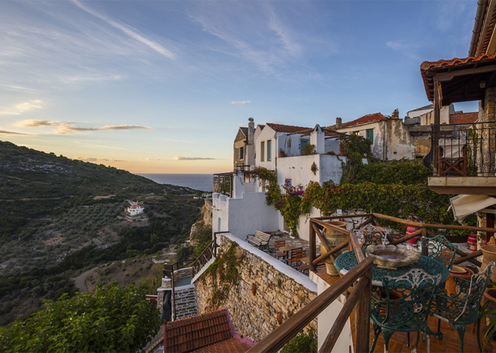 Panoramic view from a balcony, with mountains and the sea in the background