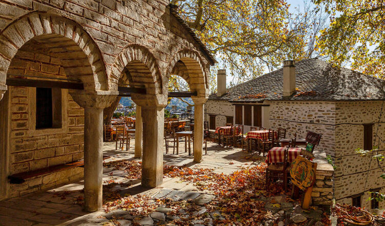 Άποψη της πλατείας του χωριού με τραπέζια, κάτω από τον πλάτανο