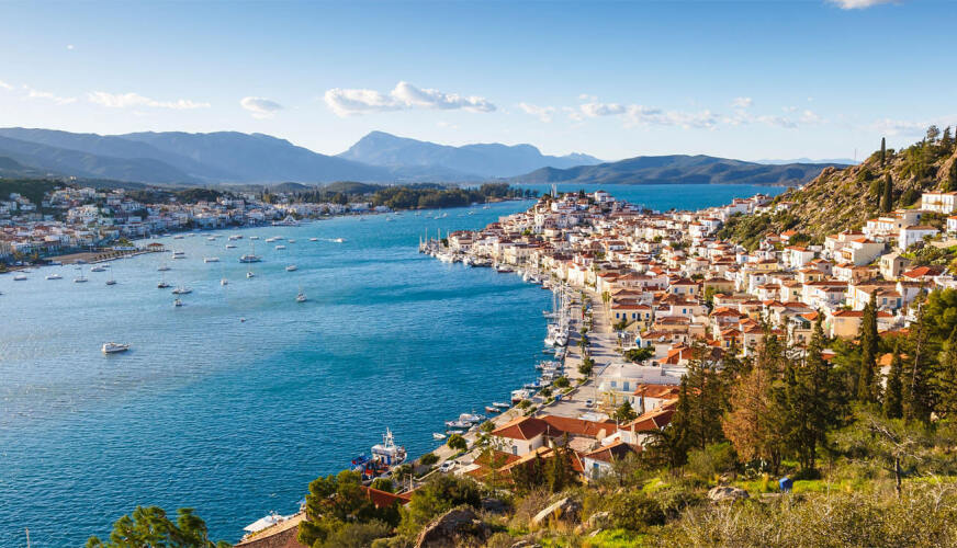 Γραφικό παραθαλάσσιο ηλιόλουστο χωριό με κεραμοσκεπές σε κανάλι με μικρά σκάφη και άλλο χωριό απέναντι. 