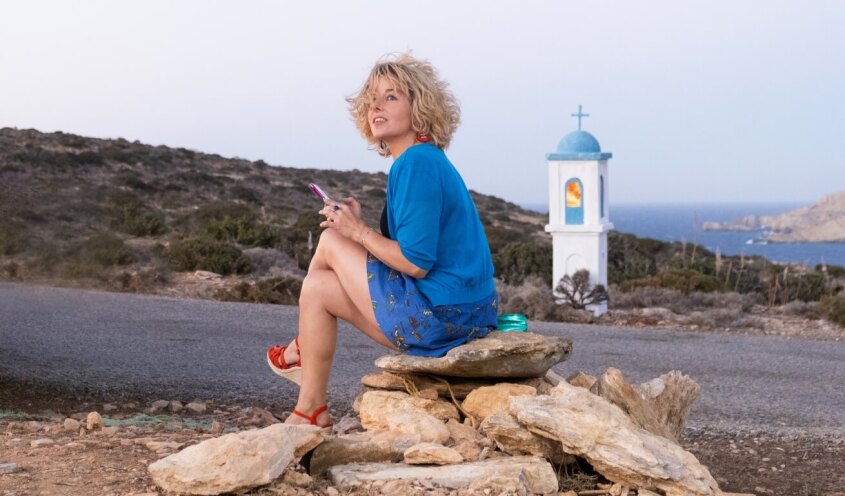 Woman sitting on the rocks in front of the sea